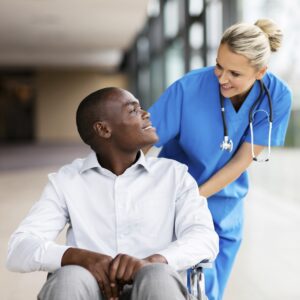 hospital employee talking to patient while pushing their wheelchair