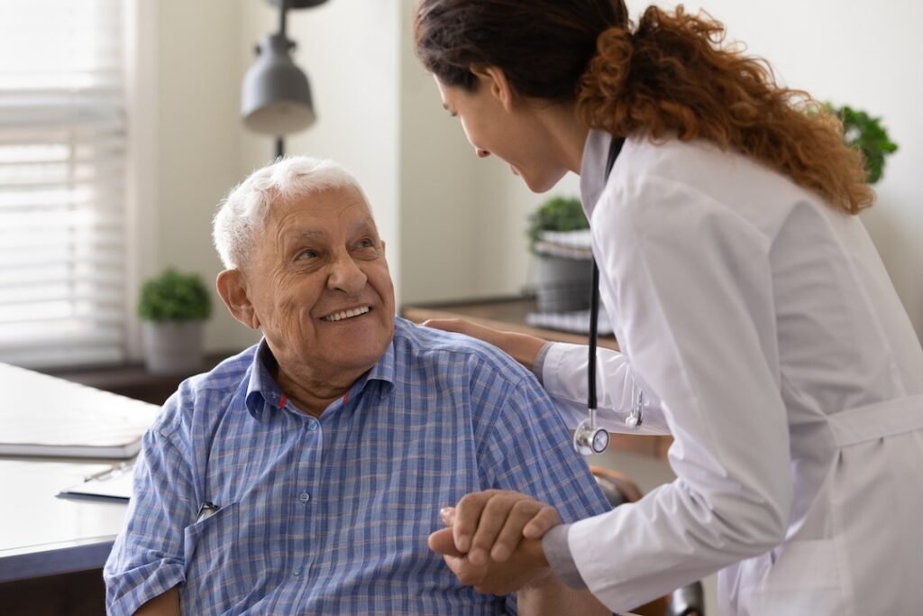 Doctor helping smiling elderly man